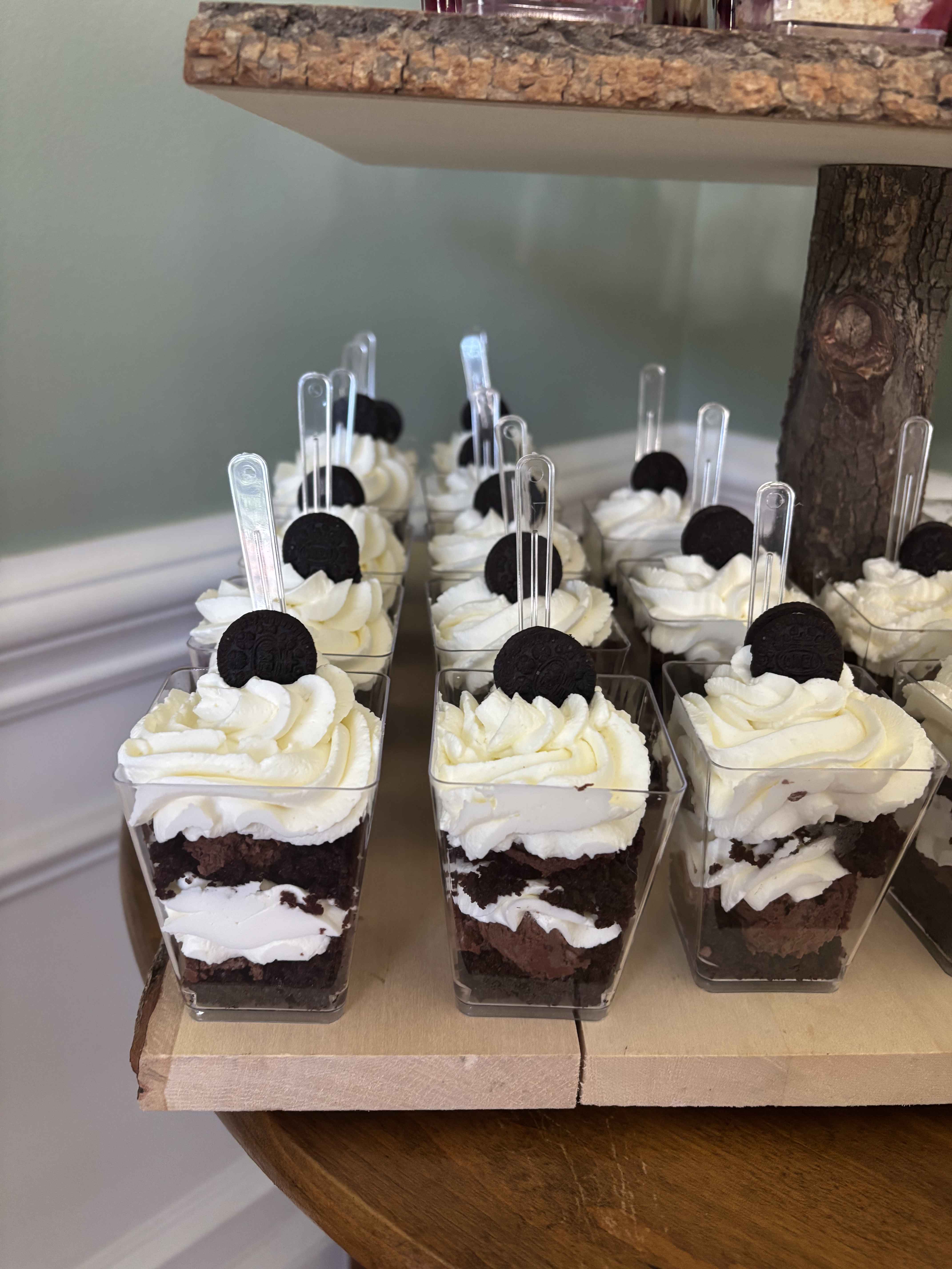 Individual Oreo dessert cups in a grid on a rustic catering display